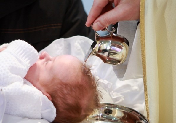 A baby being baptized in a baptismal font
AI-generated content may be incorrect.
