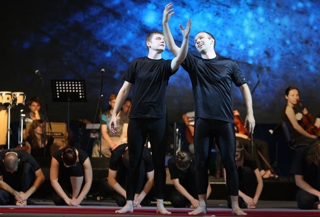 A pair of men in black shirts on a stage AI-generated content may be incorrect.