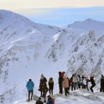 A group of people standing on a snowy mountain AI-generated content may be incorrect.