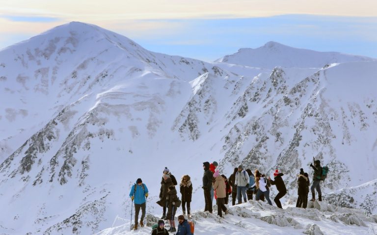 A group of people standing on a snowy mountain AI-generated content may be incorrect.