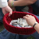 A person holding a red bowl full of money AI-generated content may be incorrect.