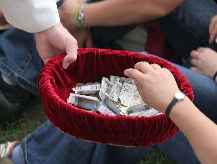 A person holding a red bowl full of money AI-generated content may be incorrect.
