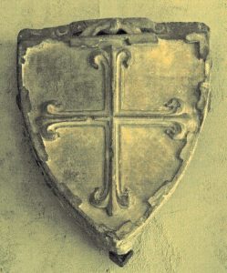 A stone shield with a cross AI-generated content may be incorrect.