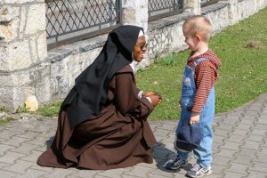 nun talking to small child