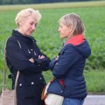 A couple of women standing in front of a field AI-generated content may be incorrect.