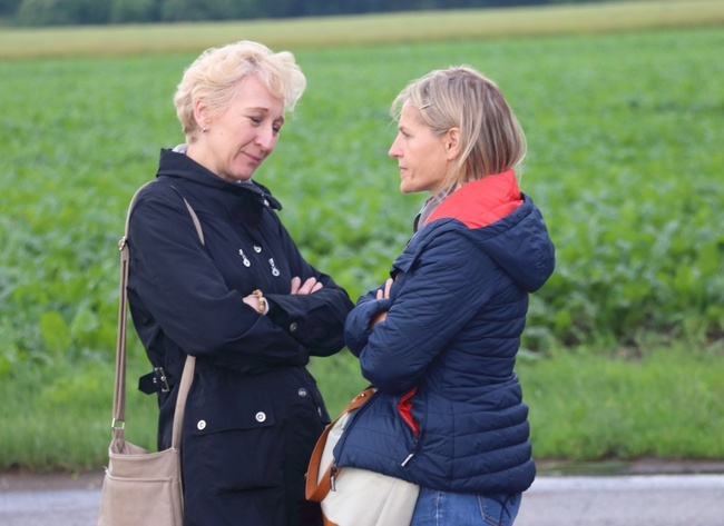 A couple of women standing in front of a field AI-generated content may be incorrect.