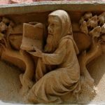 A stone carving of a person holding a book AI-generated content may be incorrect.