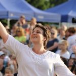 A person holding her hands up and smiling Description automatically generated